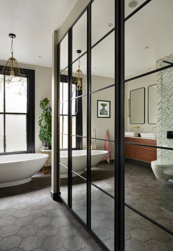 Inspiration for a large contemporary master bathroom in London with a freestanding tub, an open shower, a wall-mount toilet, gray tile, marble, grey walls, a trough sink, marble benchtops, black floor, an open shower and cement tiles.