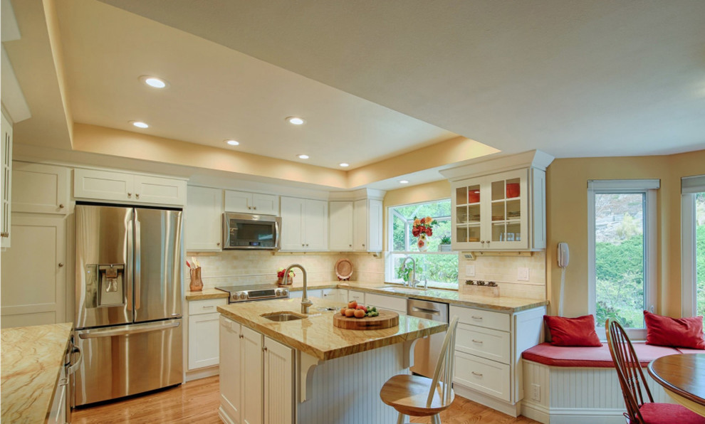 Kitchen - transitional l-shaped medium tone wood floor kitchen idea with an undermount sink, flat-panel cabinets, white cabinets, beige backsplash, stainless steel appliances and an island