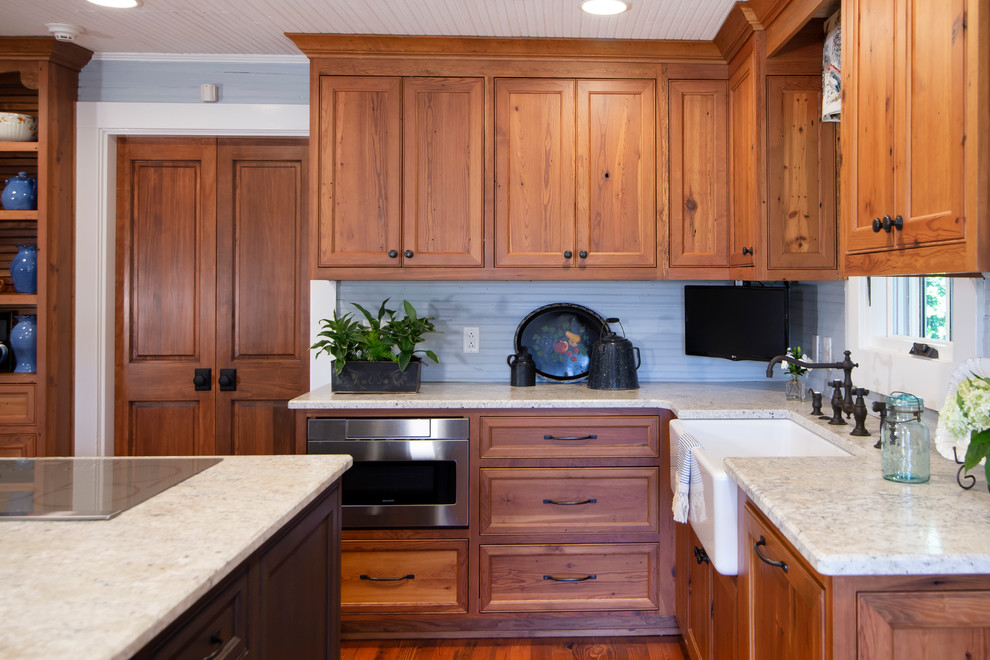 Photo of a mid-sized country l-shaped separate kitchen in Charlotte with beaded inset cabinets, medium wood cabinets, quartzite benchtops, medium hardwood floors, with island and white benchtop.