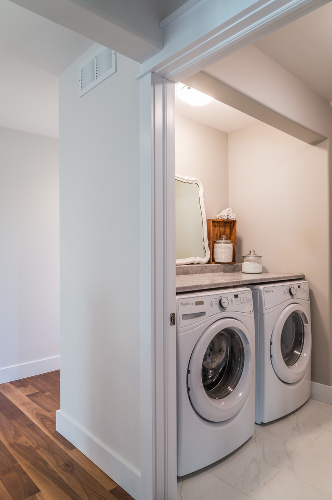 Design ideas for a mid-sized u-shaped utility room in Toronto with beige walls and a side-by-side washer and dryer.