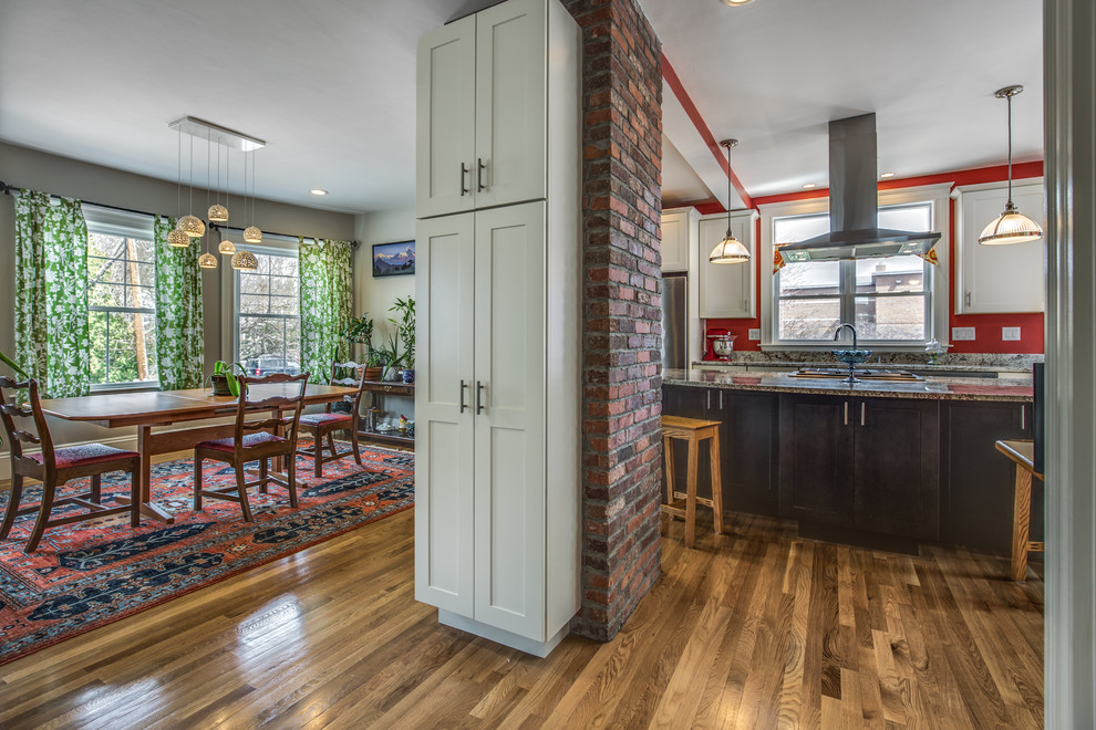 Mid-sized transitional galley light wood floor and beige floor eat-in kitchen photo in Boston with an undermount sink, shaker cabinets, white cabinets, granite countertops, red backsplash, stainless steel appliances and an island