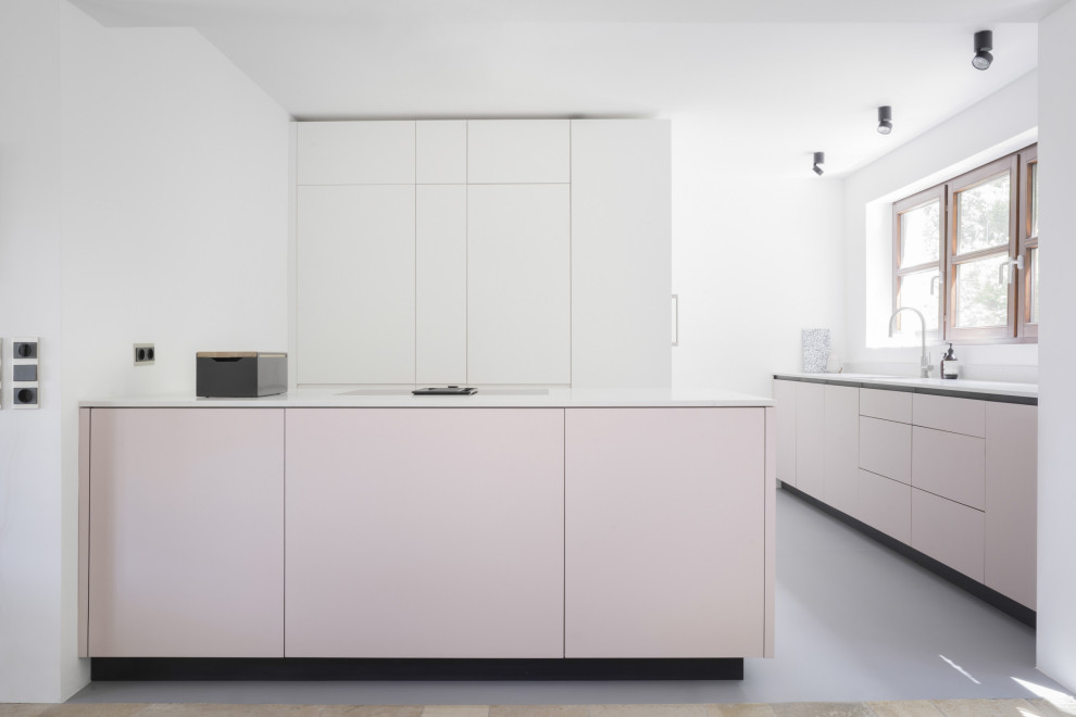 This is an example of a large modern galley eat-in kitchen in Berlin with a drop-in sink, flat-panel cabinets, pink cabinets, quartz benchtops, white splashback, window splashback, panelled appliances, linoleum floors, with island, grey floor and white benchtop.