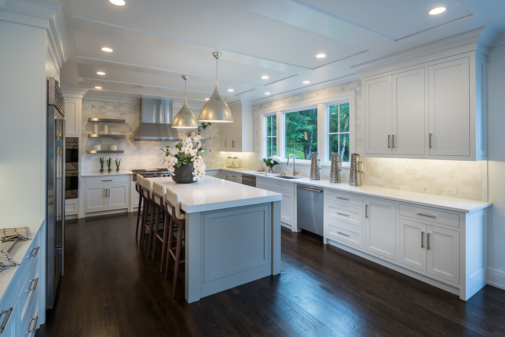 Design ideas for a large transitional u-shaped eat-in kitchen in New York with an undermount sink, shaker cabinets, white cabinets, quartz benchtops, white splashback, stone tile splashback, stainless steel appliances, dark hardwood floors, with island and brown floor.