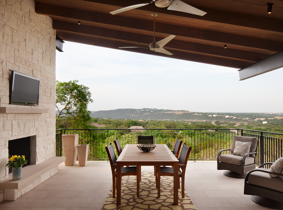 Inspiration for a mid-sized contemporary side yard patio in Austin with a fire feature, tile and a roof extension.