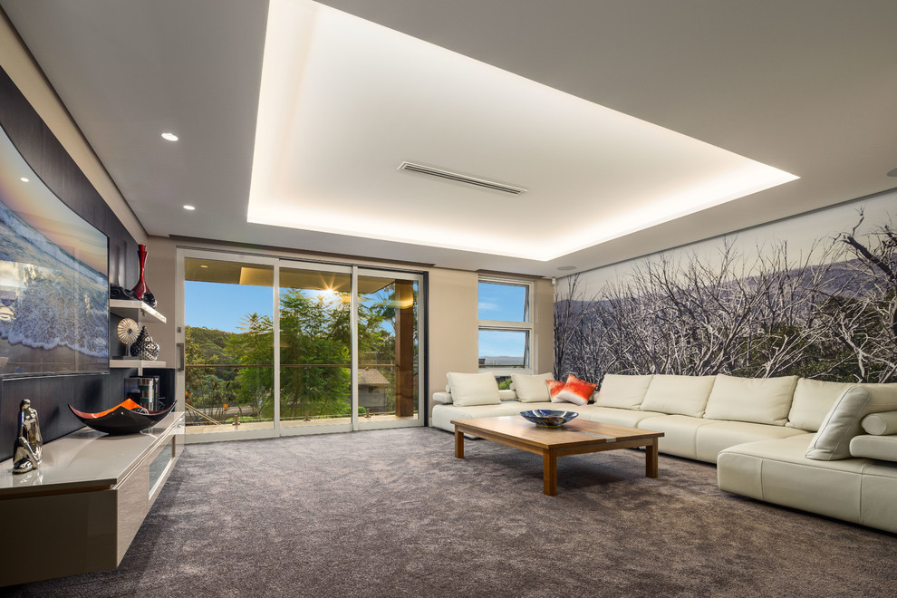 This is an example of a large contemporary open concept living room in Sydney with beige walls, carpet and a wall-mounted tv.