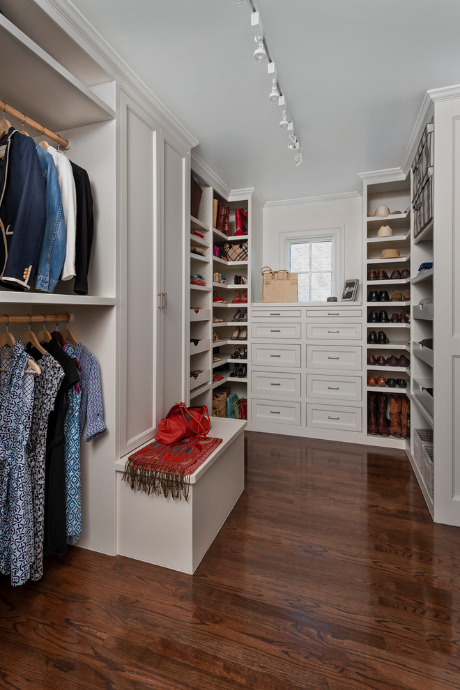 Photo of a large women's dressing room in Houston with recessed-panel cabinets, white cabinets and dark hardwood floors.