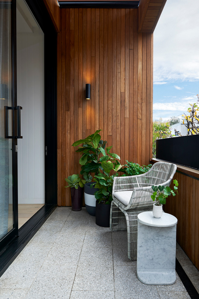 Inspiration for a small contemporary balcony in Melbourne with a roof extension.