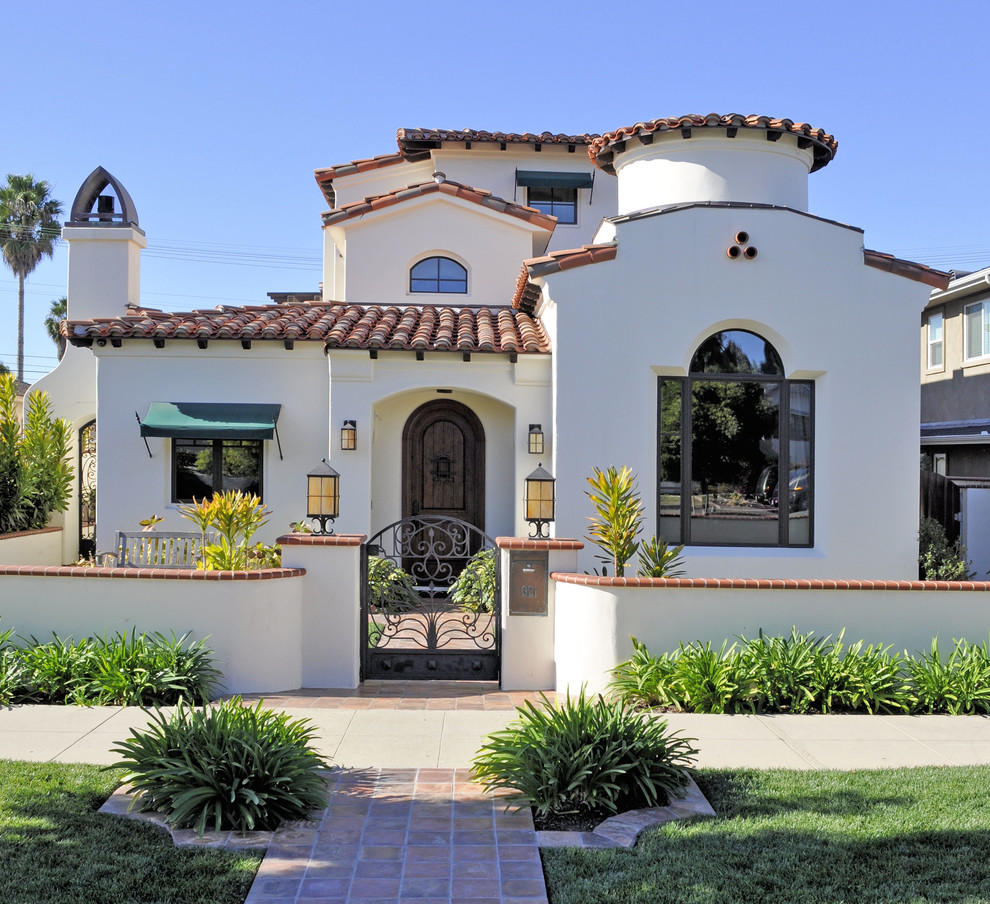 Design ideas for a large mediterranean three-storey stucco white house exterior in San Diego with a hip roof.