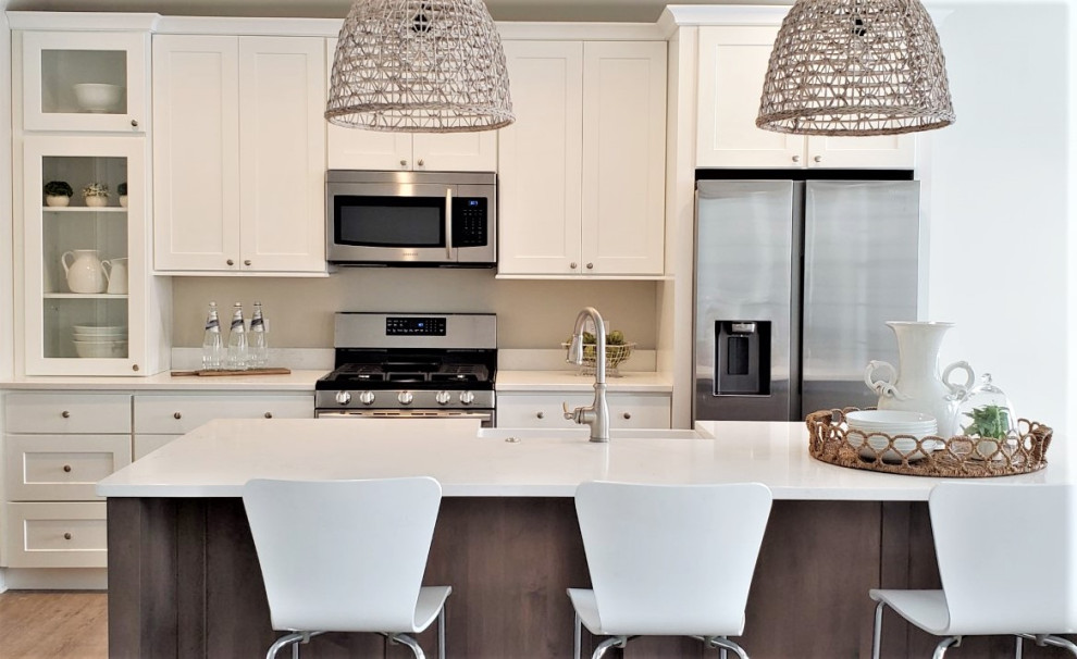 Mid-sized transitional galley vinyl floor and brown floor eat-in kitchen photo in Chicago with a farmhouse sink, shaker cabinets, white cabinets, quartz countertops, stainless steel appliances, an island and white countertops