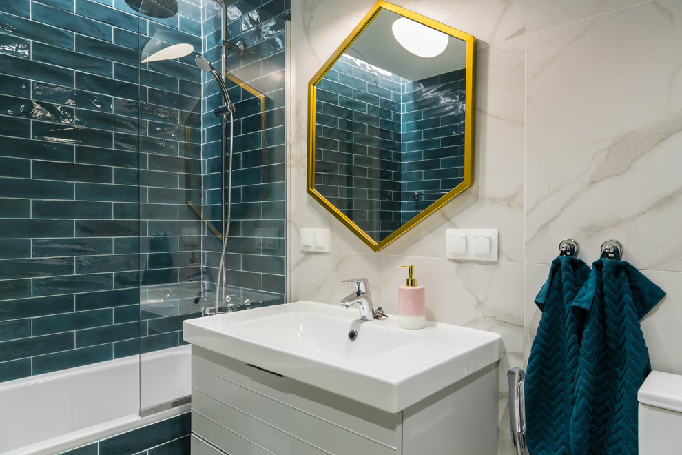 This is an example of a mid-sized master bathroom in Saint Petersburg with flat-panel cabinets, white cabinets, an undermount tub, a shower/bathtub combo, a one-piece toilet, white tile, subway tile, white walls, ceramic floors, a drop-in sink, grey floor and a shower curtain.