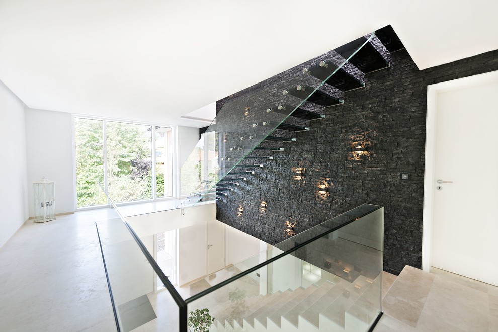 Large contemporary glass floating staircase in Munich with glass railing.
