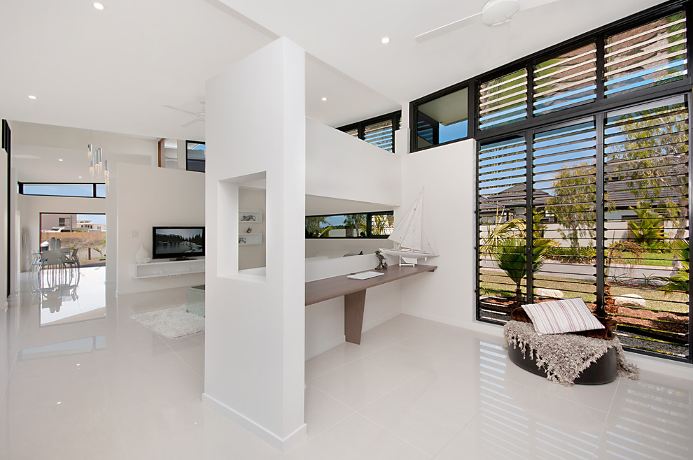 This is an example of a mid-sized contemporary study room in Cairns with white walls, porcelain floors and a built-in desk.