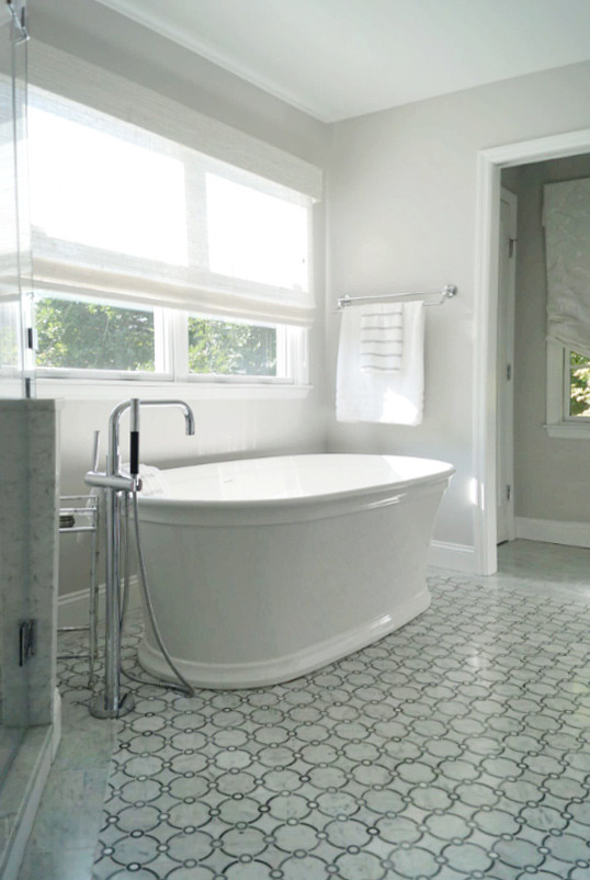 Inspiration for a mid-sized transitional master white tile and ceramic tile gray floor and ceramic tile freestanding bathtub remodel with a hinged shower door, white countertops, recessed-panel cabinets, white cabinets, gray walls, an undermount sink and solid surface countertops