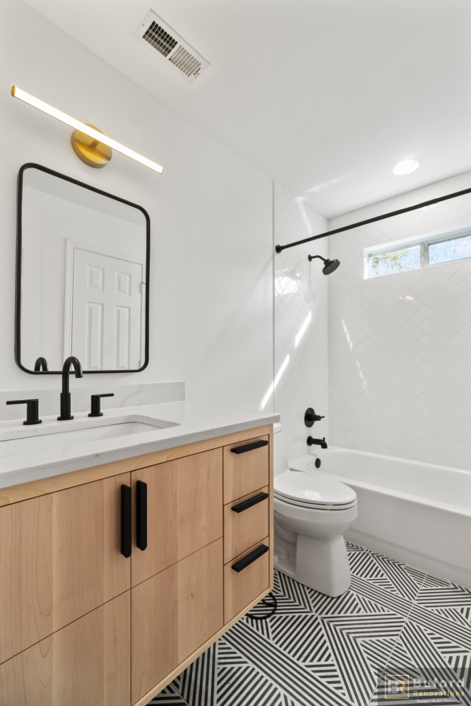 Photo of a small contemporary bathroom in Atlanta with furniture-like cabinets, light wood cabinets, an alcove tub, an alcove shower, white tile, ceramic tile, quartzite benchtops, white benchtops, a single vanity, a floating vanity, a one-piece toilet, white walls, ceramic floors, black floor and a shower curtain.