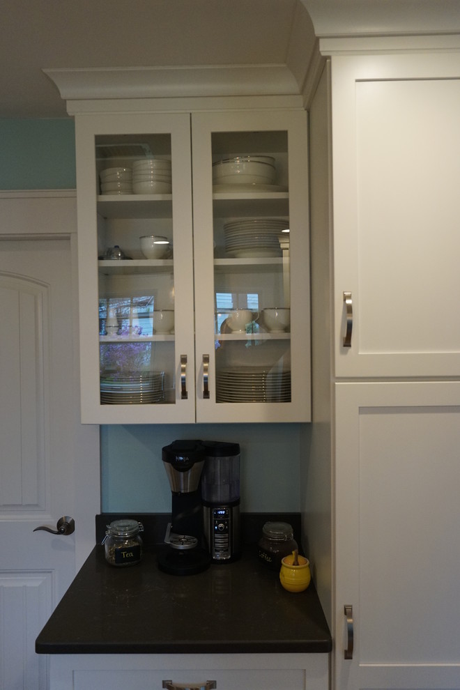 Mid-sized transitional u-shaped medium tone wood floor eat-in kitchen photo in Boston with an undermount sink, shaker cabinets, gray cabinets, quartz countertops, black backsplash, stainless steel appliances and an island