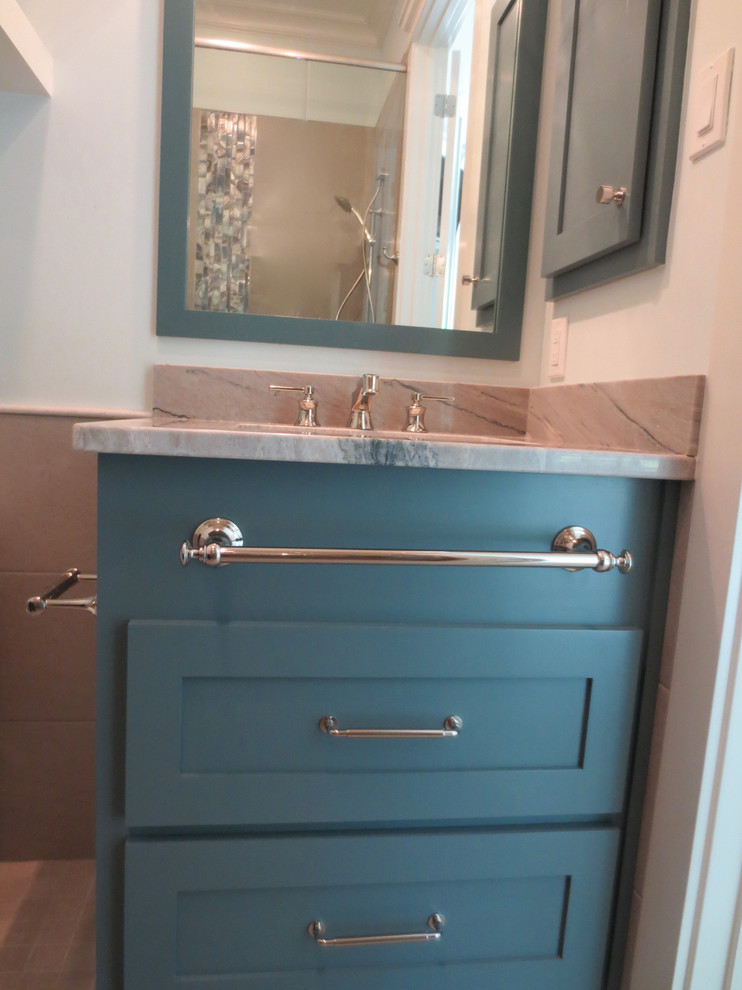 This is an example of a mid-sized modern kids bathroom in New Orleans with shaker cabinets, green cabinets, a curbless shower, a one-piece toilet, gray tile, porcelain tile, blue walls, porcelain floors, an undermount sink, granite benchtops, grey floor and a hinged shower door.