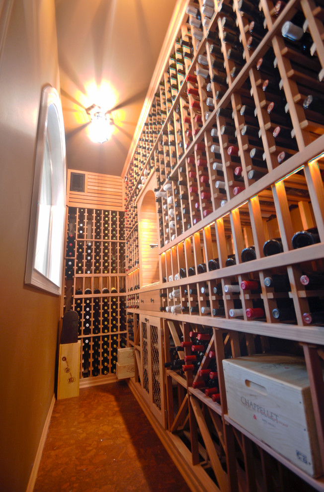 Large arts and crafts wine cellar in Tampa with cork floors, storage racks and brown floor.