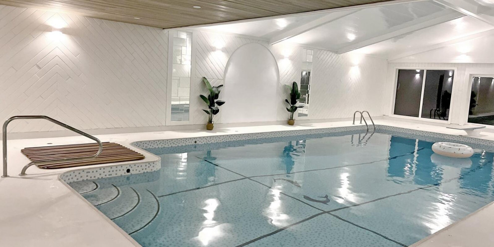 Modelo de casa de la piscina y piscina elevada escandinava grande interior y rectangular con suelo de hormigón estampado