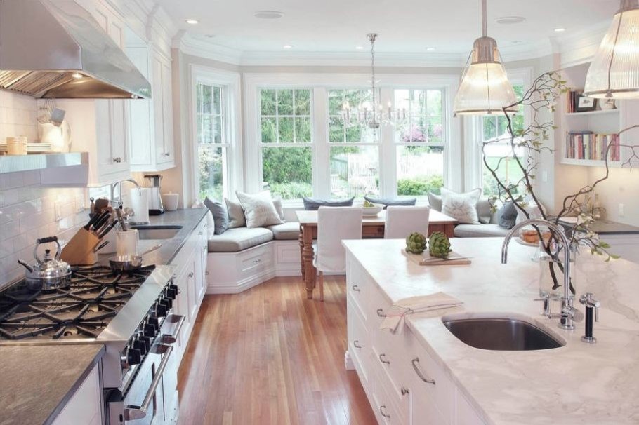 Example of a large transitional u-shaped medium tone wood floor and brown floor kitchen design in DC Metro with recessed-panel cabinets, white cabinets, quartzite countertops, white backsplash, subway tile backsplash, an island and white countertops
