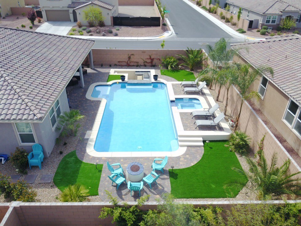 Inspiration for a large traditional backyard l-shaped lap pool in Las Vegas with a hot tub and brick pavers.