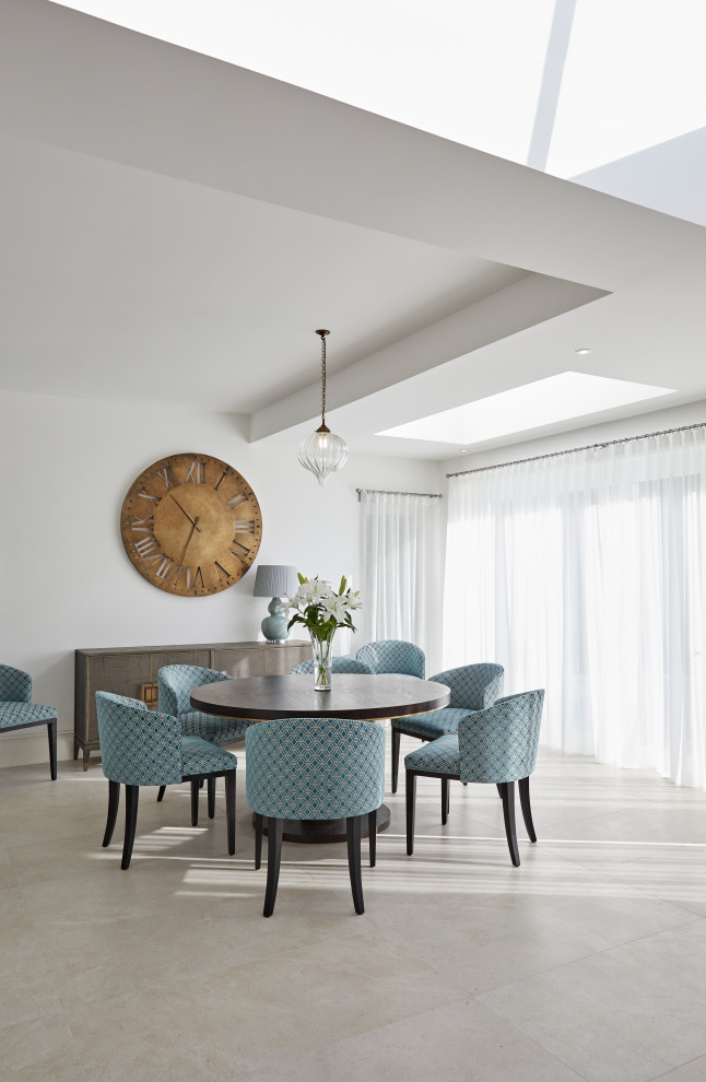 This is an example of a transitional open plan dining in London with white walls, no fireplace and beige floor.