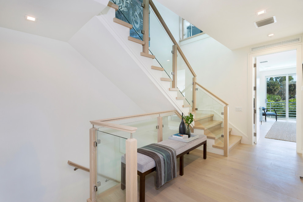 Inspiration for a mid-sized modern wood l-shaped staircase in Miami with glass risers and wood railing.
