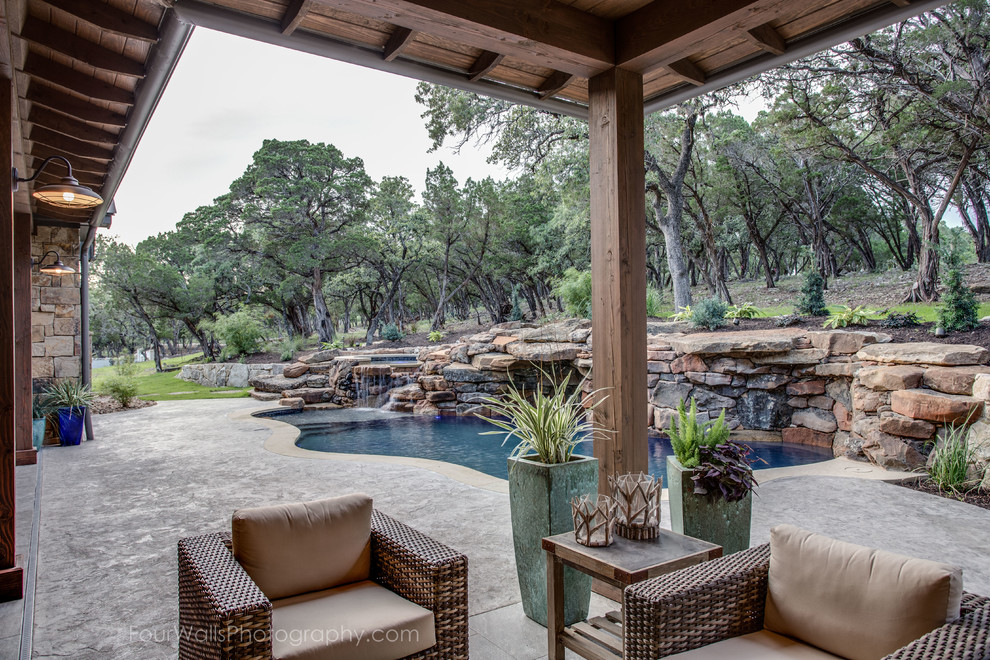 Design ideas for a large traditional backyard patio in Austin with a water feature, concrete slab and a roof extension.