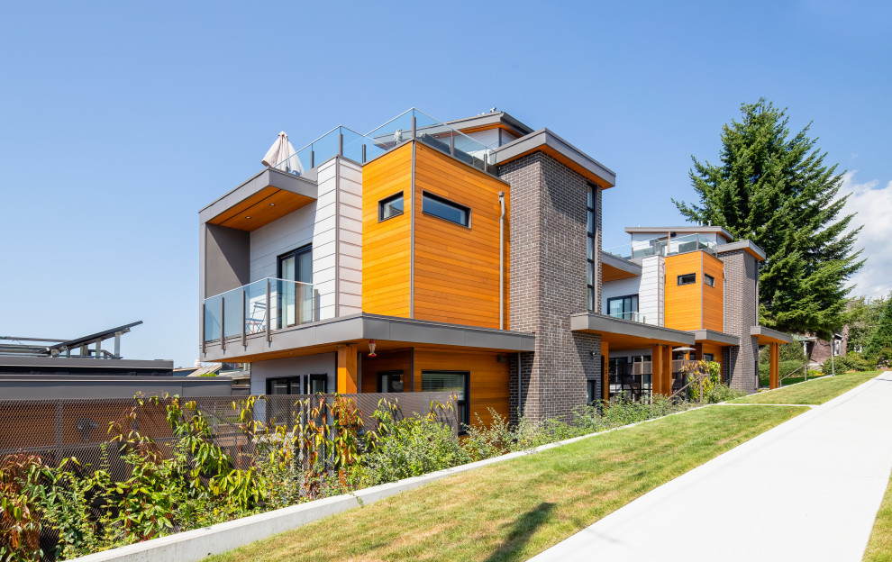 Inspiration for a large contemporary house exterior in Vancouver with a flat roof and a metal roof.