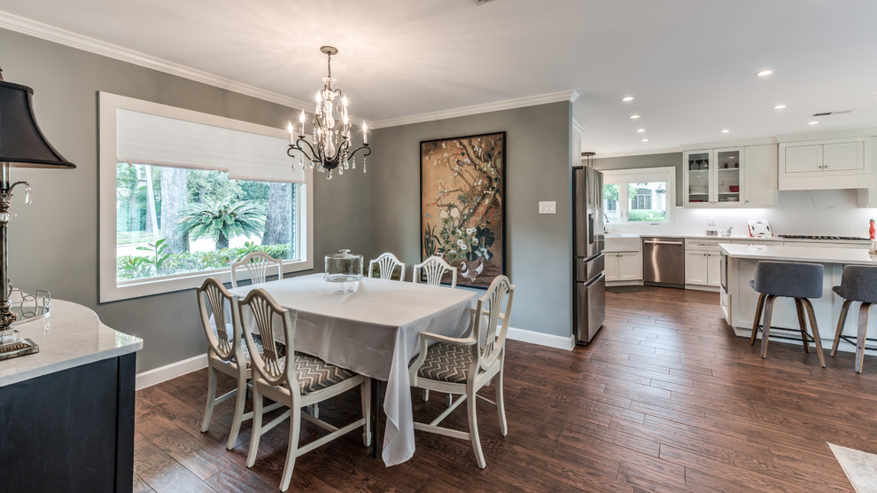 Photo of a mid-sized traditional dining room in Houston with grey walls, porcelain floors, a standard fireplace, a tile fireplace surround and brown floor.