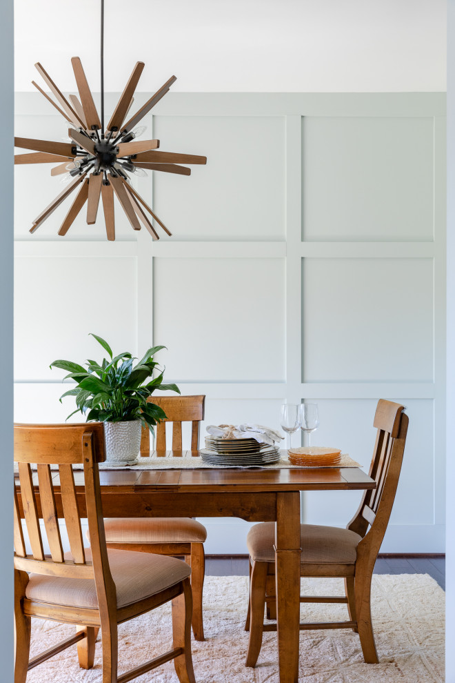 Immagine di una piccola sala da pranzo aperta verso la cucina costiera con pareti blu, pavimento marrone e pareti in legno