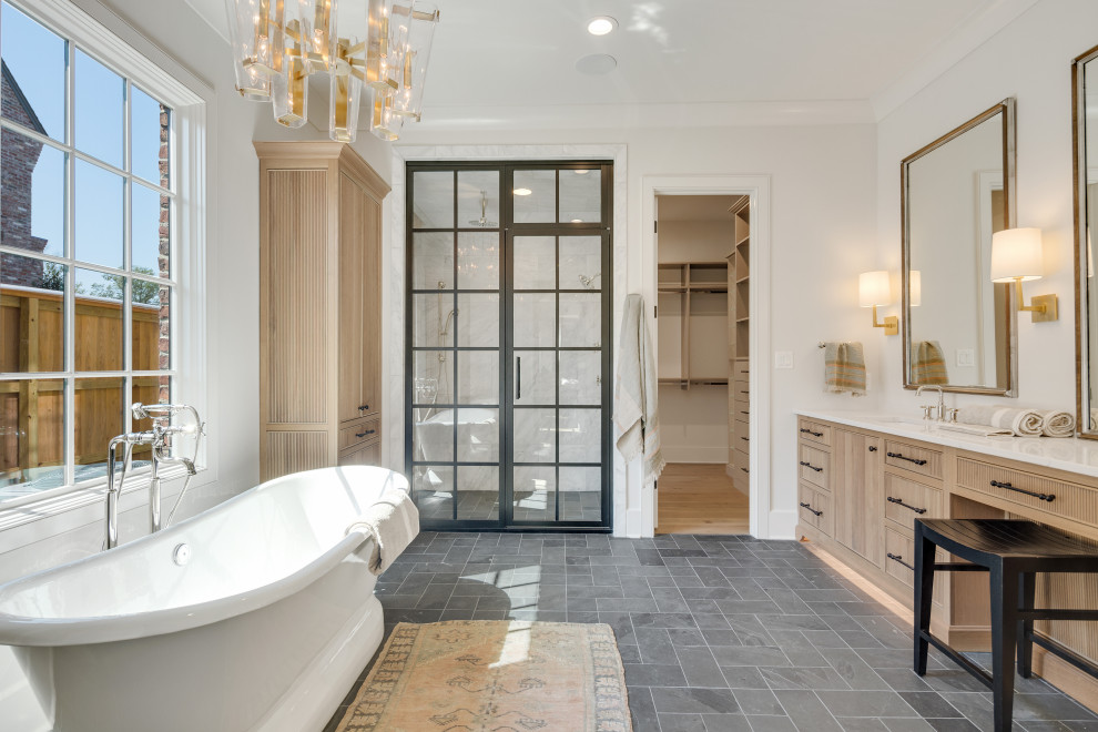 This is an example of a transitional master bathroom in Other with medium wood cabinets, a freestanding tub, an alcove shower, white walls, an undermount sink, grey floor, a hinged shower door, white benchtops and flat-panel cabinets.
