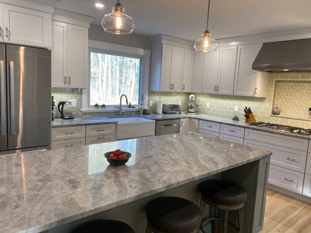 Inspiration for a mid-sized contemporary l-shaped eat-in kitchen in Portland Maine with a farmhouse sink, shaker cabinets, grey cabinets, quartz benchtops, green splashback, porcelain splashback, stainless steel appliances, medium hardwood floors, with island, multi-coloured floor and grey benchtop.