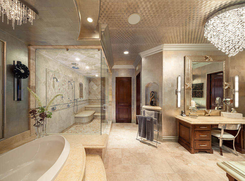 Inspiration for an expansive tropical master bathroom in Los Angeles with raised-panel cabinets, medium wood cabinets, a drop-in tub, a double shower, beige tile, travertine, grey walls, travertine floors, limestone benchtops, beige floor and a hinged shower door.