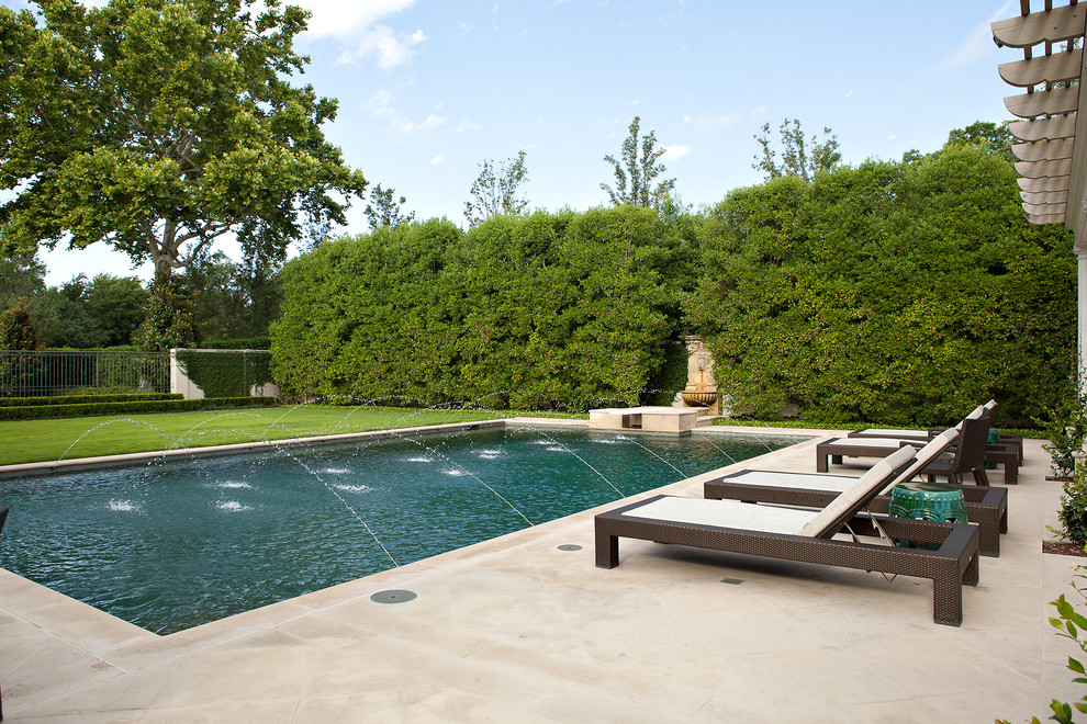 Traditional rectangular pool in Dallas with a water feature.