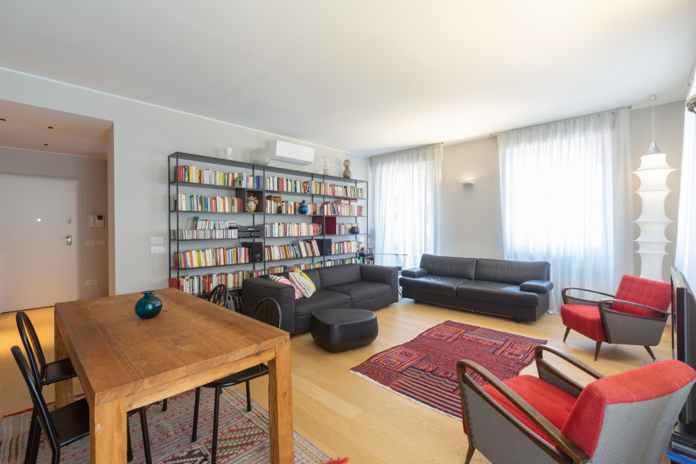 На фото: большая изолированная гостиная комната в современном стиле с серыми стенами и деревянным полом с