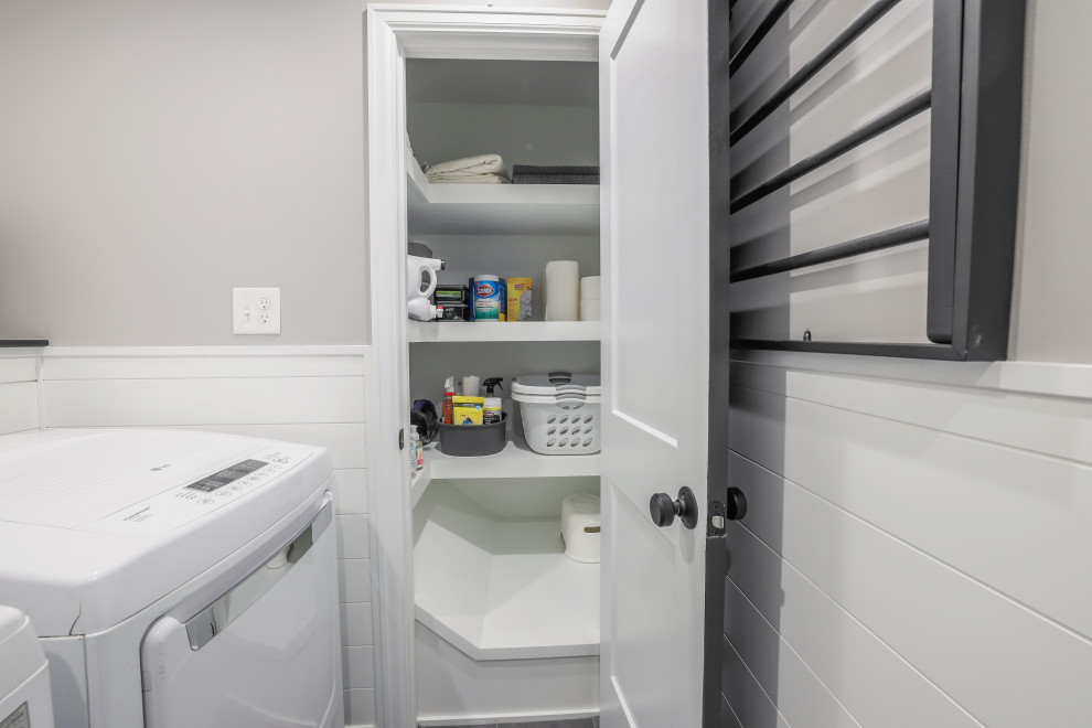 Inspiration for a small transitional single-wall dedicated laundry room in Columbus with shiplap splashback, grey walls, porcelain floors, a side-by-side washer and dryer, grey floor and wallpaper.