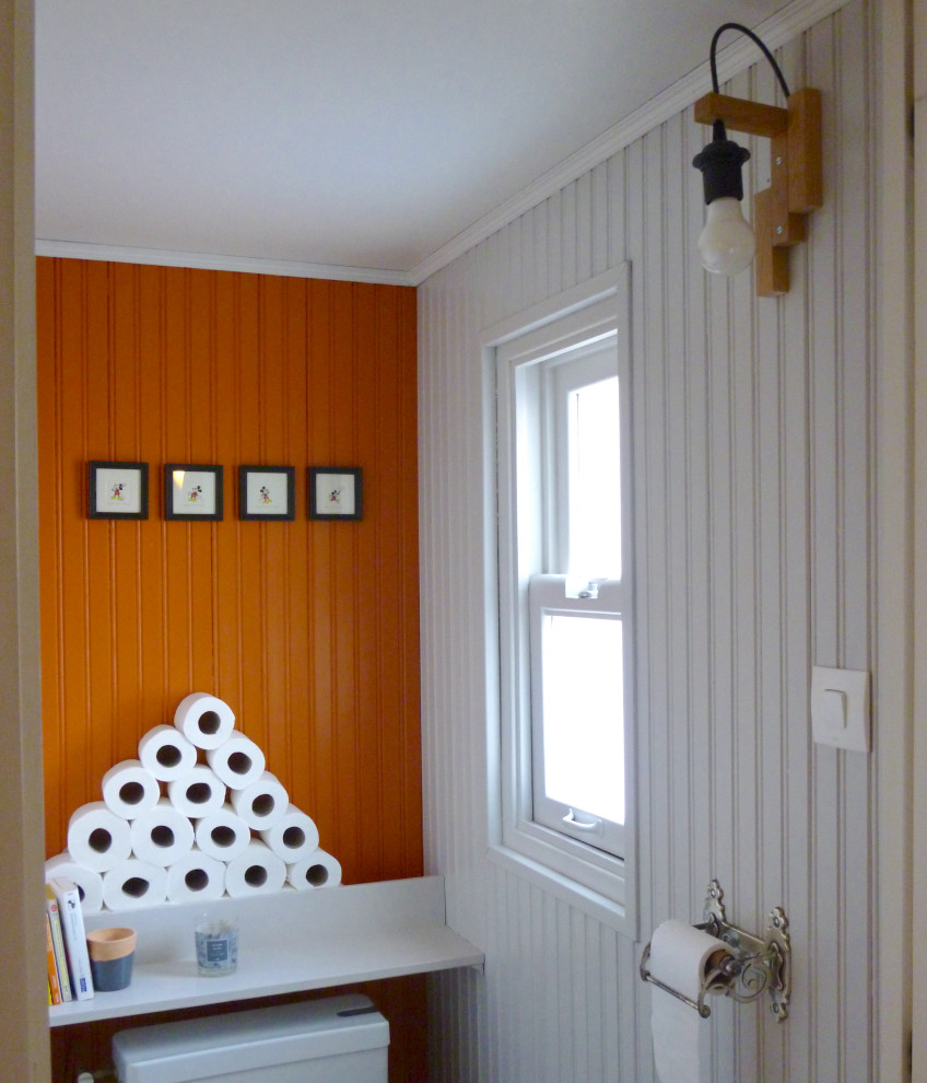 Foto de aseo contemporáneo pequeño con sanitario de una pieza, parades naranjas y panelado