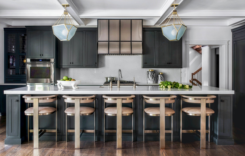 This is an example of a transitional kitchen in Philadelphia with an undermount sink, shaker cabinets, black cabinets, white splashback, stainless steel appliances, dark hardwood floors, with island, brown floor and white benchtop.