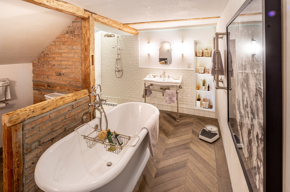 Inspiration för stora klassiska badrum med dusch, med ett fristående badkar, en öppen dusch, en toalettstol med separat cisternkåpa, vit kakel, ett konsol handfat och brunt golv