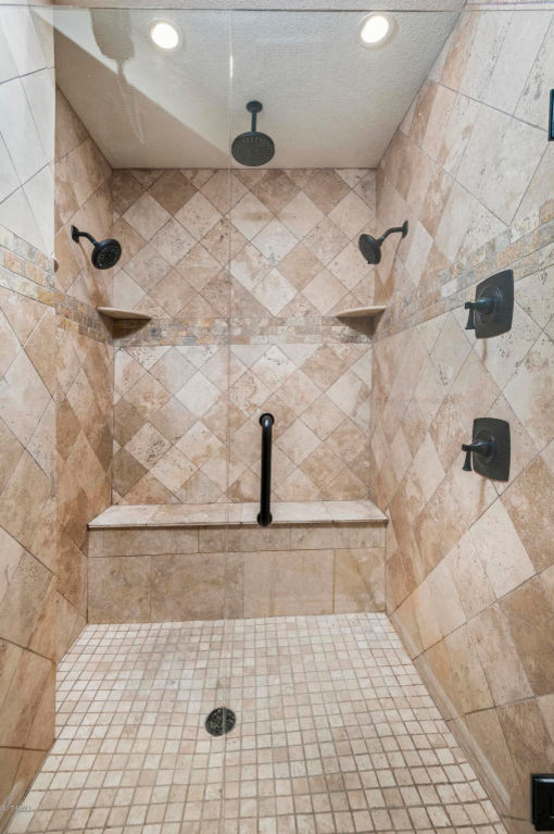 This is an example of a mid-sized traditional master bathroom in Phoenix with raised-panel cabinets, white cabinets, an alcove shower, brown tile, stone tile, beige walls, travertine floors, an undermount sink, granite benchtops, brown floor and grey benchtops.