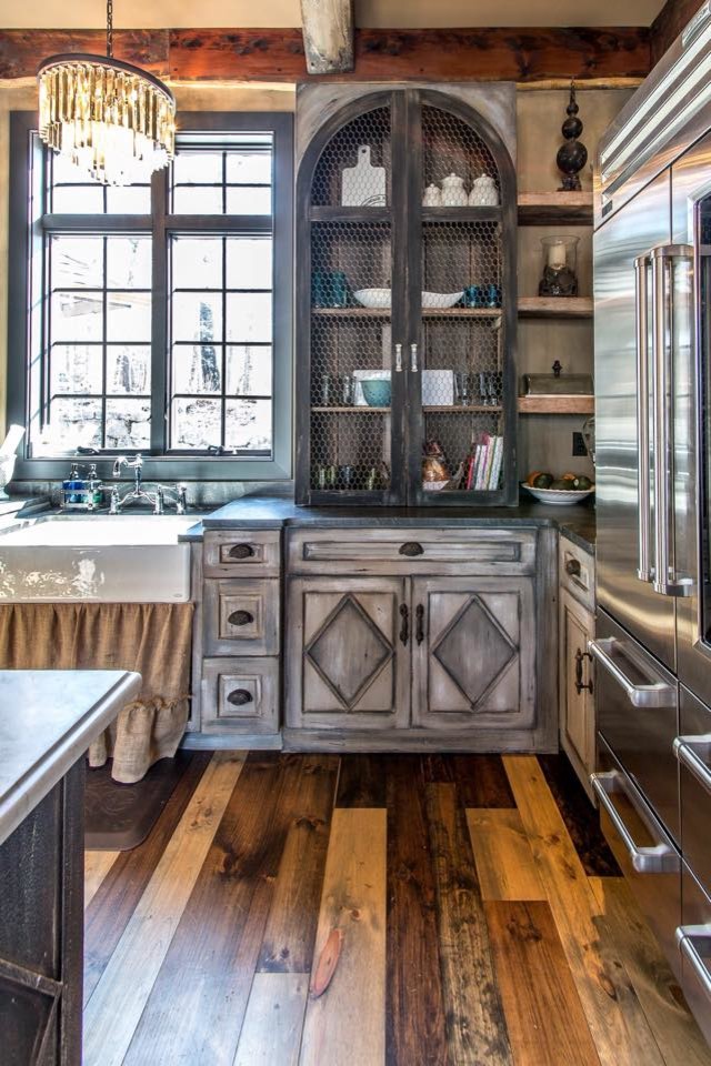 Inspiration for a mid-sized rustic l-shaped medium tone wood floor and brown floor eat-in kitchen remodel in St Louis with a farmhouse sink, distressed cabinets, gray backsplash, stainless steel appliances, an island, raised-panel cabinets and marble countertops