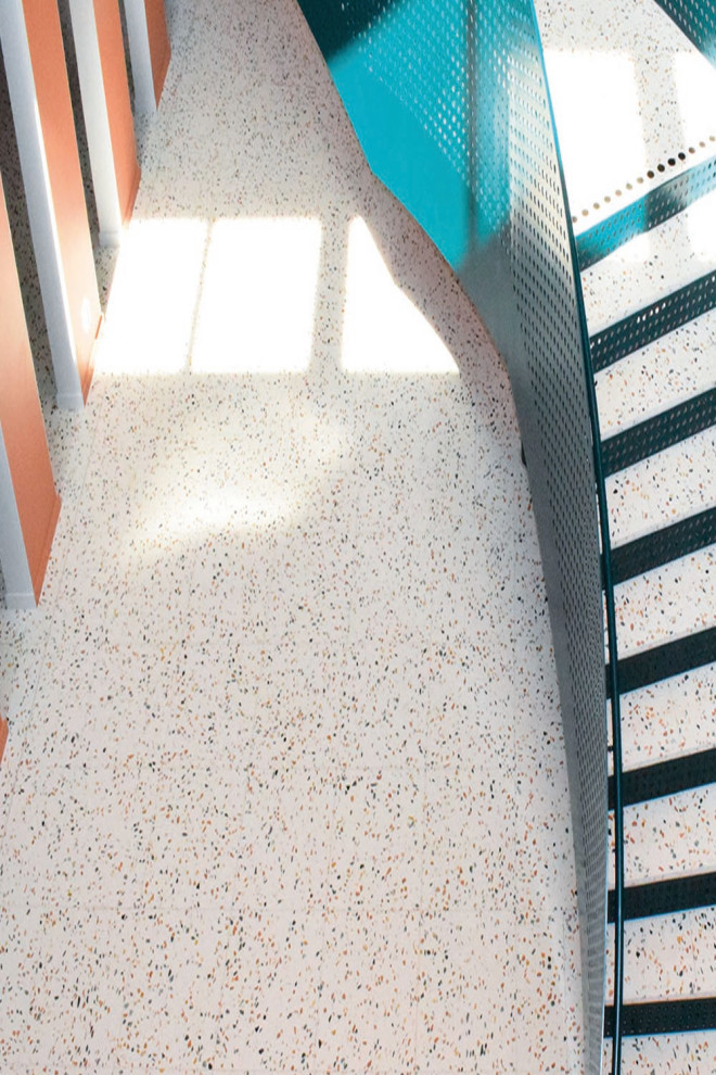 Пример оригинального дизайна: огромный коридор в стиле модернизм с оранжевыми стенами, полом из терраццо и серым полом