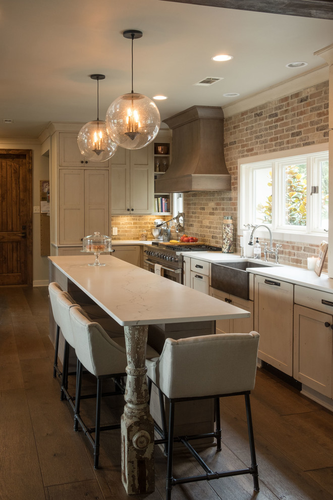 Inspiration for a large transitional galley dark wood floor and brown floor open concept kitchen remodel with a farmhouse sink, shaker cabinets, quartz countertops, brown backsplash, brick backsplash, stainless steel appliances and an island