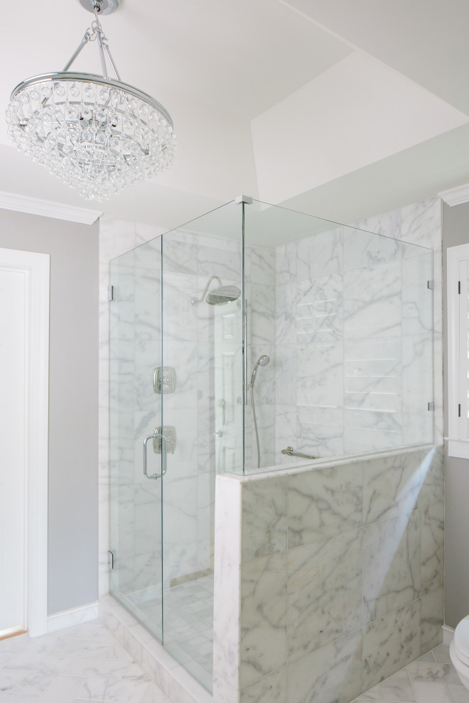 Example of a large transitional master white tile and marble tile marble floor, white floor, double-sink and tray ceiling corner shower design in Atlanta with furniture-like cabinets, white cabinets, a two-piece toilet, gray walls, an undermount sink, marble countertops, a hinged shower door, white countertops, a niche and a built-in vanity