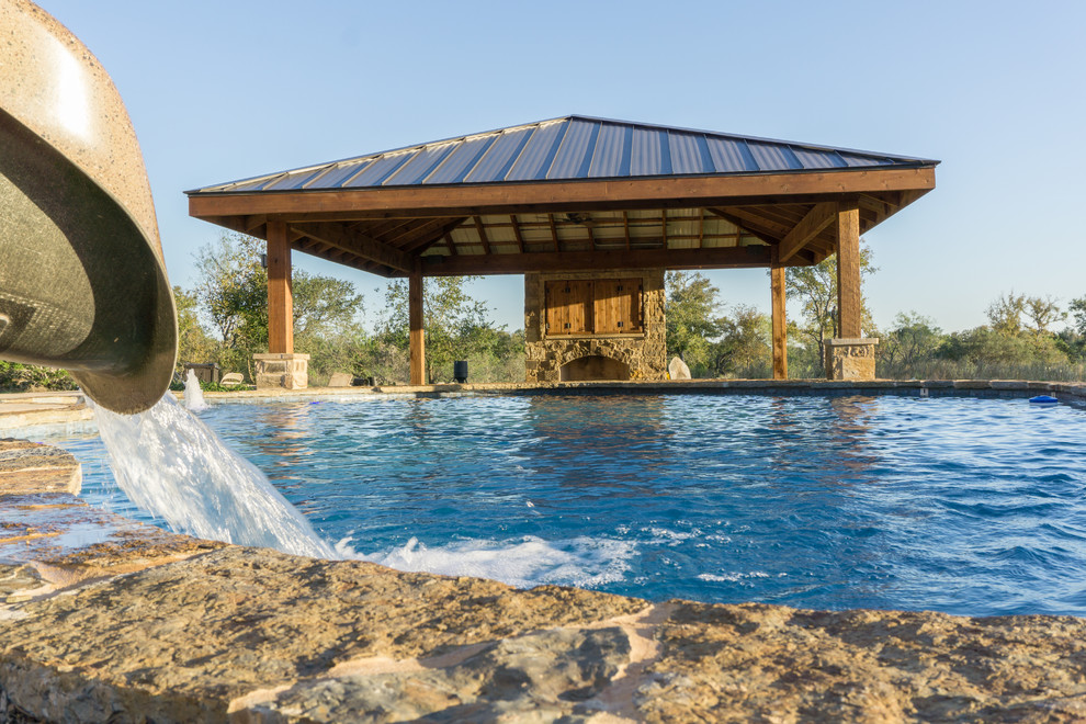 Large mountain style backyard stone and custom-shaped pool fountain photo in Austin