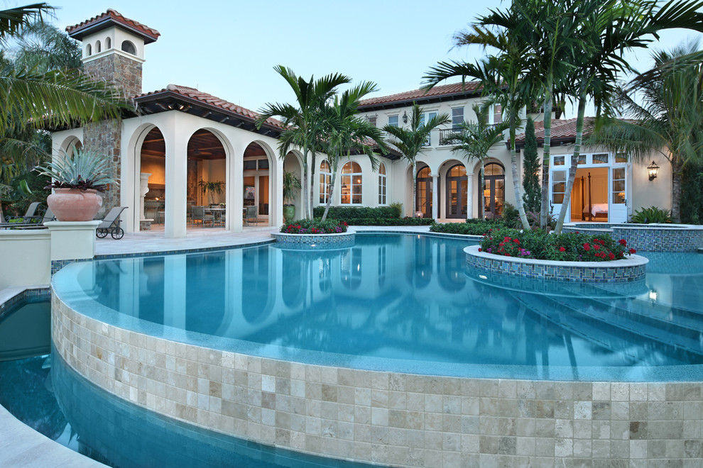 Design ideas for a large mediterranean backyard custom-shaped lap pool in Miami with tile.