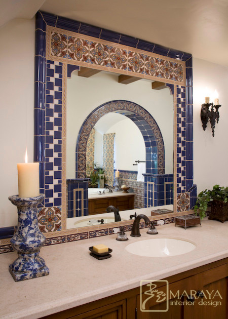 Expansive mediterranean master bathroom in Santa Barbara with an undermount sink, recessed-panel cabinets, dark wood cabinets, a drop-in tub, an alcove shower, a two-piece toilet, blue tile, white walls and limestone floors.