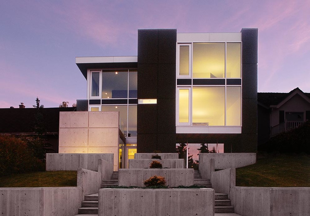 Inspiration for a contemporary three-storey black house exterior in Calgary with mixed siding and a flat roof.
