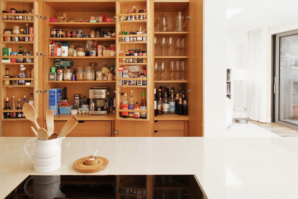 Large modern kitchen pantry in Sussex with flat-panel cabinets, medium wood cabinets and wood benchtops.