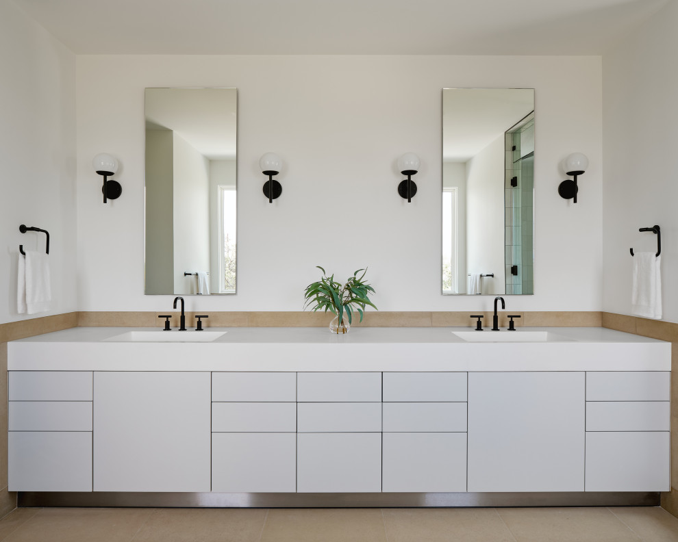 Photo of a large contemporary master bathroom in Austin with flat-panel cabinets, grey cabinets, beige tile, limestone, white walls, an integrated sink, solid surface benchtops, white benchtops, a double vanity and a built-in vanity.